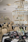 Sala weselna glamour z złotymi instalacjami świetlnymi Elegancka sala weselna z kaskadowymi złotymi instalacjami świetlnymi nad stołami gości.