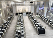 Ekskluzywna aranżacja sali weselnej w stylu black & gold Elegancka sala weselna z czarnymi stołami, złotymi świecznikami i białą ścianką ślubną.